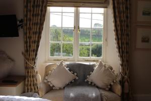 Aveton GiffordCourt Barton Farm的带沙发和大窗户的客厅