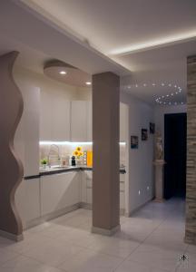 罗马Giglio Luxury Apartment - Chroma Italy的一间厨房,里面配有白色的橱柜和柱子