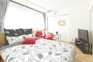 东京ESPERANZA103 広い綺麗快適高速WiFi的一间卧室设有黑白床和电视。