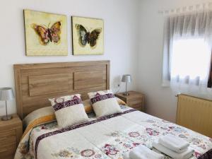 阿赫尔La Caseta del Montsec的卧室配有一张床铺,墙上挂着3只蝴蝶