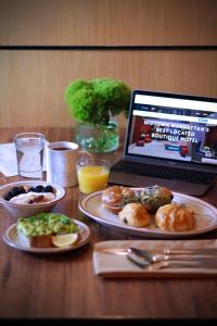 纽约珍珠酒店的一张带食物盘的桌子和一台笔记本电脑