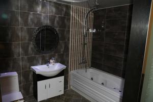 安东市高丽酒店的浴室配有盥洗盆、卫生间、浴缸和镜子