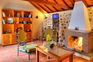 伊科德洛斯维诺斯HolidaynorthTenerife Casa rural Montiel的客厅设有壁炉、桌子和椅子