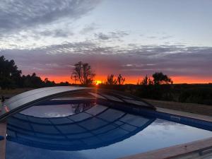 圣特奥托纽Quinta das Beldroegas - Casas de Campo的日落时分,在游泳池边,阳光照耀