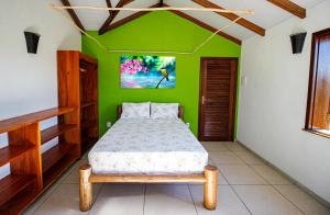 UnaFazenda Eco-Jardim的一间卧室设有绿色的墙壁,里面设有一张床