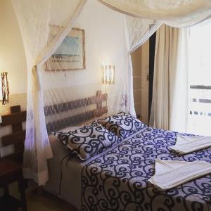 卡波布里奥拉布里斯酒店的一间卧室配有一张带天蓬和窗户的床