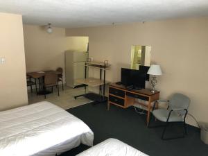 埃德蒙顿Jockey Motel的酒店客房配有一张床和一张书桌及一台电视
