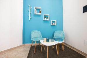 古斯皮尼B&B Vico 10的蓝色墙壁前的两把椅子和一张桌子
