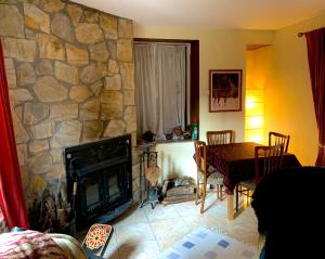 CobrerosCasa Dono Sanabria的客厅配有桌子和石头壁炉