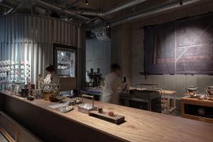 京都TSUGU Kyoto Sanjo by THE SHARE HOTELS的两个人在厨房准备食物