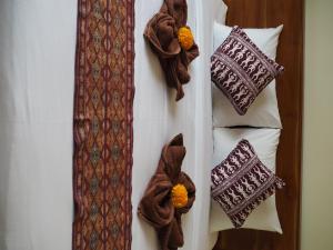 乌布Kampung Sari Homestay的一组枕头和床上的领带