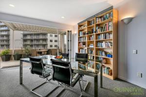 奥克兰QV Downtown Executive Penthouse Parking Wifi - 782的一个带玻璃桌和椅子的图书馆