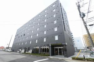 土浦市The Celecton Tsuchiura Ekimae的大街上一座带窗户的大型灰色建筑