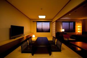 熊本其宽温泉域贝尔酒店的配有桌椅和电视的客房
