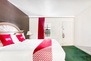 Bald KnobOYO Hotel Bald Knob near Searcy AR的一间卧室配有一张带红色和白色枕头的大床
