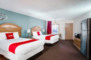 Bald KnobOYO Hotel Bald Knob near Searcy AR的酒店客房配有两张床和一台冰箱