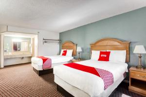 Bald KnobOYO Hotel Bald Knob near Searcy AR的酒店客房带两张带红白色枕头的床