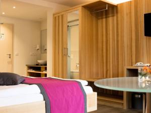 EggolsheimBrauerei_Gasthof Pfister的卧室配有一张床和一张桌子