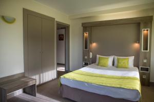 Saint-Martin-dʼUriage梅桑酒店的一间卧室配有一张带绿色枕头的大床
