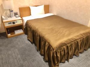 松本松本市南十字星经济型酒店的酒店客房,设有床铺和床头柜