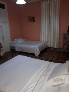 丹吉尔Pension Safari的一间卧室设有两张床,窗户配有窗帘