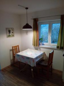 ArchkogelHaus Höber的一间带桌子和两把椅子的用餐室以及窗户。