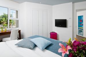 埃拉特埃拉特U珊瑚海滩俱乐部全包酒店的一间卧室配有一张带粉红色手提箱的床