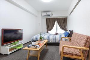 京都Cozy house 31, free wifi a rented electric bicycle的一间带床和电视的客厅