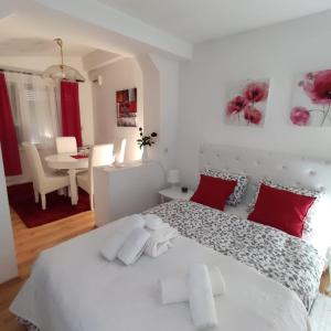 贝尔格莱德Gardos的卧室配有带红色枕头的大型白色床