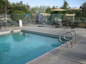 Reedley艾治沃特旅馆的一个带桌椅的庭院内的游泳池