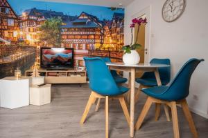 斯特拉斯堡Strasbourg Appart Cosy Hyper Centre的一间带桌子和蓝色椅子的用餐室