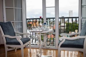 顺化柏勒酒店的客房设有一张桌子和两把椅子以及一个阳台。