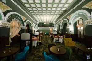 彼得罗沙尼Hotel La Belle Epoque的一间带桌椅和天花板的用餐室