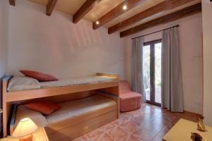 科斯提克斯YupiHome Finca S'Erissal de Costitx的客房设有两张双层床和一张桌子。