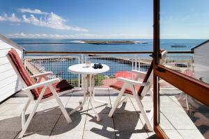 黑尔戈兰岛Haus Rooad Weeter的一个带桌椅的海景阳台
