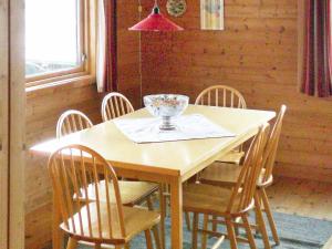 HeggjafrisliaThree-Bedroom Holiday home in Nordfjordeid 2的一张木桌,上面有椅子和玻璃碗