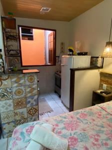 阿布拉奥Flat aluguel Abraão 2,Ilha Grande的客房设有带一张床和一台冰箱的厨房