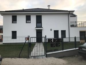 凯斯特海伊Jada Lakás的白色的房子,有黑色的围栏