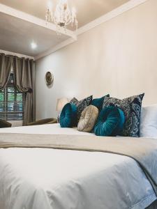 波罗瓜尼单里过夜旅馆的一间卧室配有一张带枕头的床和吊灯。