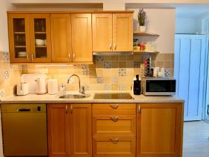斯楚雅Villa Yadranka的厨房配有木制橱柜、水槽和微波炉