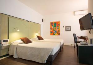 特伦托布里科斯里昂酒店的酒店客房设有两张床和一台平面电视。