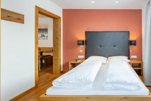 沃瑟姆阿尔伯格Alphus Appartements的一间卧室配有一张带橙色墙壁的大床