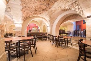 巴黎MIJE MARAIS Hostel的一间设有桌椅的餐厅,位于带石墙的房间内