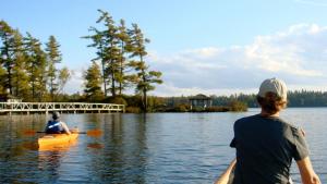 Paul SmithsWhite Pine Camp的湖上划皮艇的男人和女人