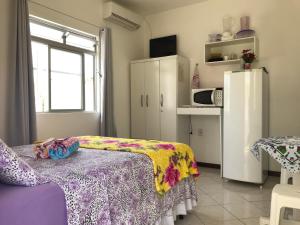 弗洛里亚诺波利斯Pousada Mera的客房设有一张床和带冰箱的厨房