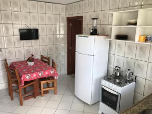 弗洛里亚诺波利斯Pousada Mera的厨房配有桌子和白色冰箱。