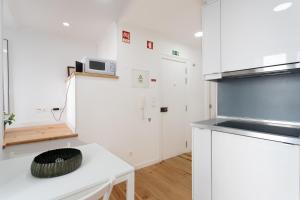 里斯本FLH Mouraria Charming Flat II的厨房配有白色橱柜和白色台面