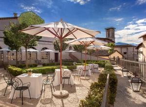 诺尔恰城堡塞内卡宫罗莱夏朵精品酒店的一组桌椅和遮阳伞