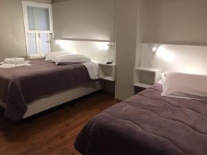 新普拉塔Pousada dos Pinheirais的一间卧室设有两张床和窗户。