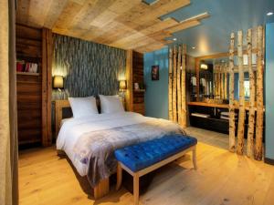 Le Petit-Bornand-lès-GlièresChalet 1703 - Open Living Hotel & Spa的一间卧室设有一张大床和蓝色的墙壁